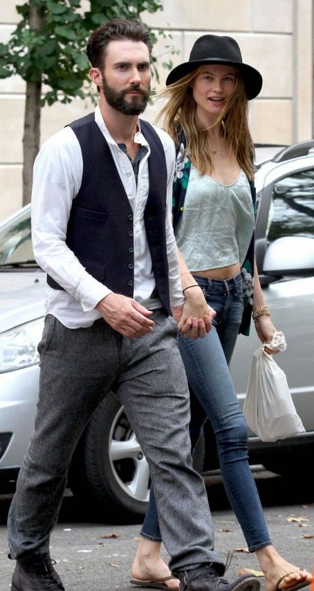 Adam Levine holds hands with his fiancee Behati Prinsloo on Sunday in New York City. (July 28)