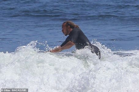 Is there ANYTHING he's not good at? Lewis Hamilton dons a wetsuit as he goes surfing with pals in Malibu ahead of the British Grand Prix