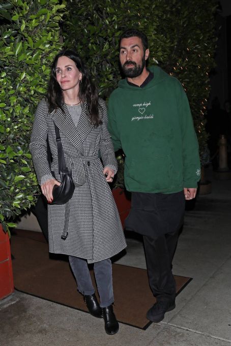 Courteney Cox – In a black and white long coat at Giorgio Baldi