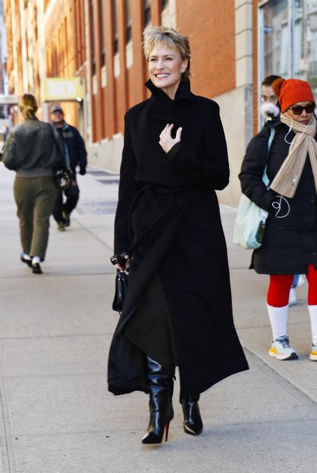 Robin Wright – In a black trench coat and knee long boots in New York